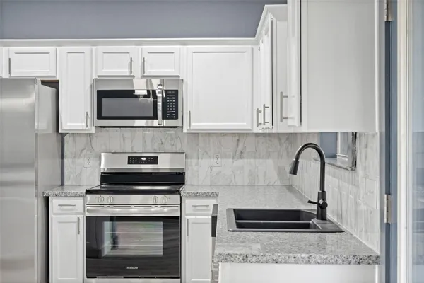 a kitchen with stainless steel appliances granite countertop a sink and cabinets