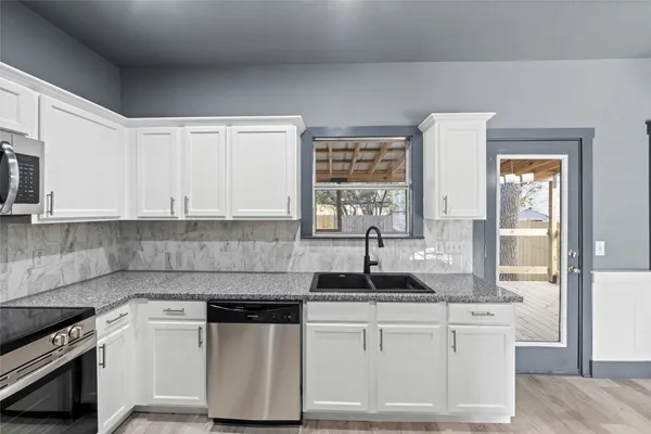 a view of an empty room and kitchen view
