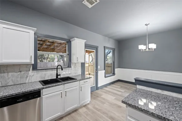 a large kitchen with stainless steel appliances kitchen island granite countertop a refrigerator a oven a stove and a sink with wooden floor