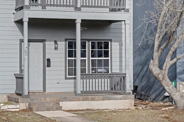 a view of a house with a small yard and wooden floor and fence