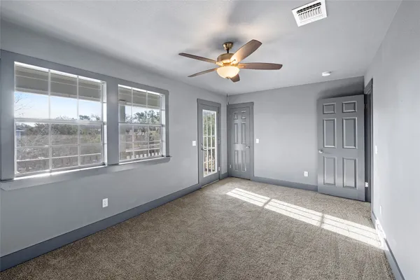 an empty room with closet and a chandelier fan