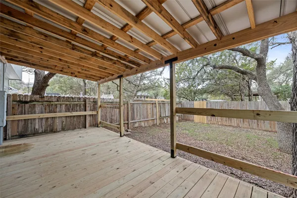 a view of a house with a yard and wooden fence