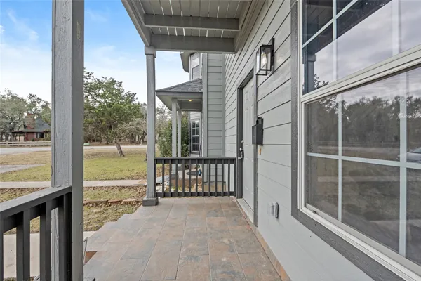 a view of a house with a floor to ceiling window next to a yard