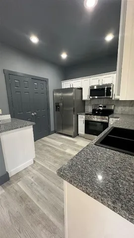 a kitchen with stainless steel appliances a sink stove and refrigerator