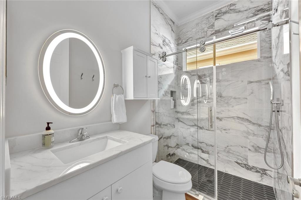 255 2nd Avenue North Naples, FL 34102 - Photo 14 of 32 a bathroom with a granite countertop sink toilet and shower