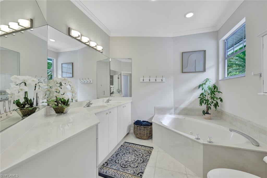 255 2nd Avenue North Naples, FL 34102 - Photo 16 of 32 a bathroom with a tub sink and mirror