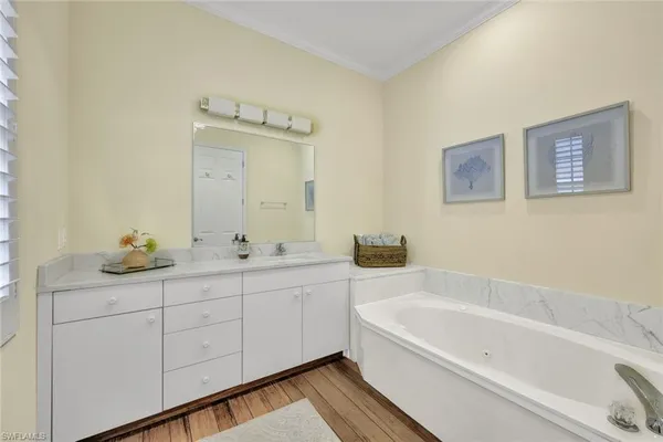 a bathroom with a tub sink and mirror