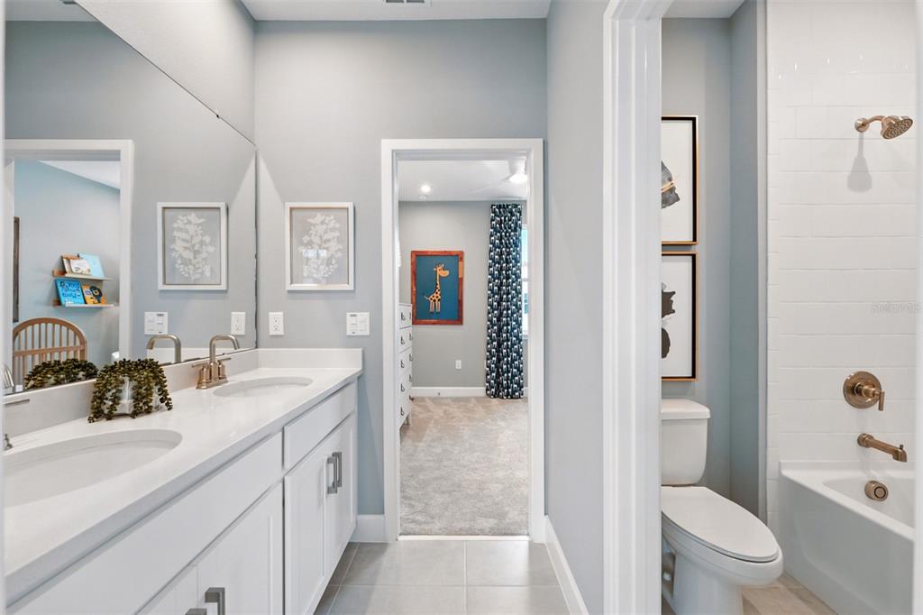1475 Seashore Circle Celebration, FL 34747 - Photo 17 of 31 a spacious bathroom with a granite countertop sink a toilet a mirror and shower