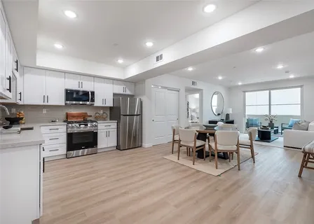 a kitchen with a refrigerator and a stove top oven