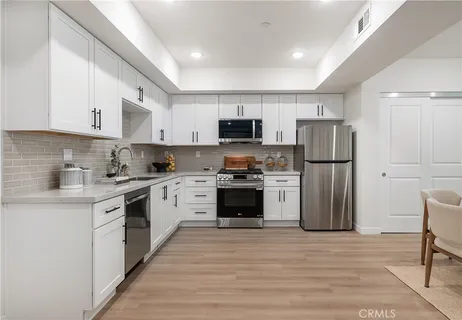 a kitchen with a refrigerator a stove top oven a sink and cabinets