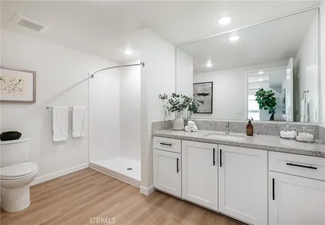 a bathroom with a double vanity sink toilet and a mirror