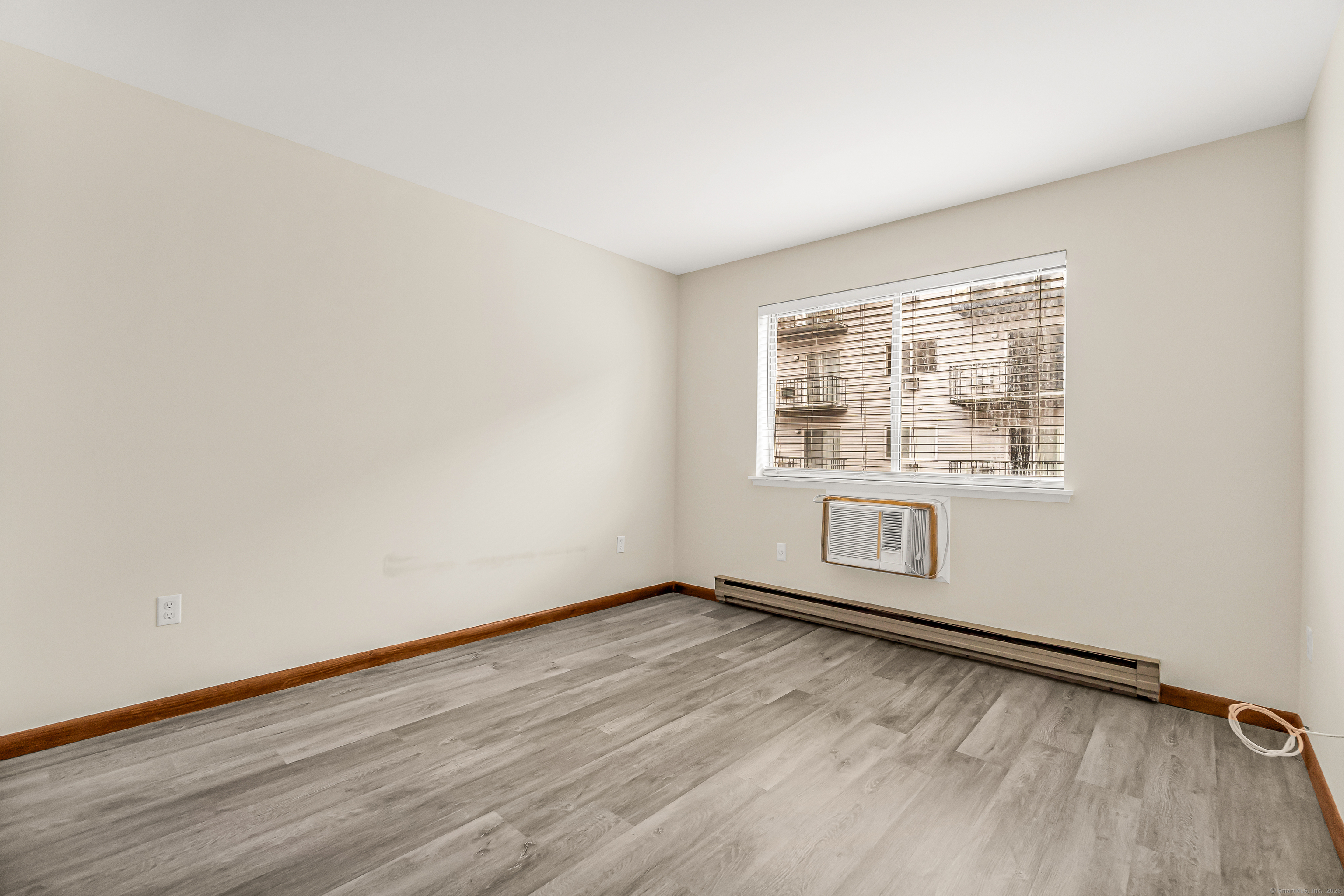 115 Short Beach Road, Unit 103 Stratford, CT 06615 - Photo 13 of 18 an empty room with wooden floor and windows