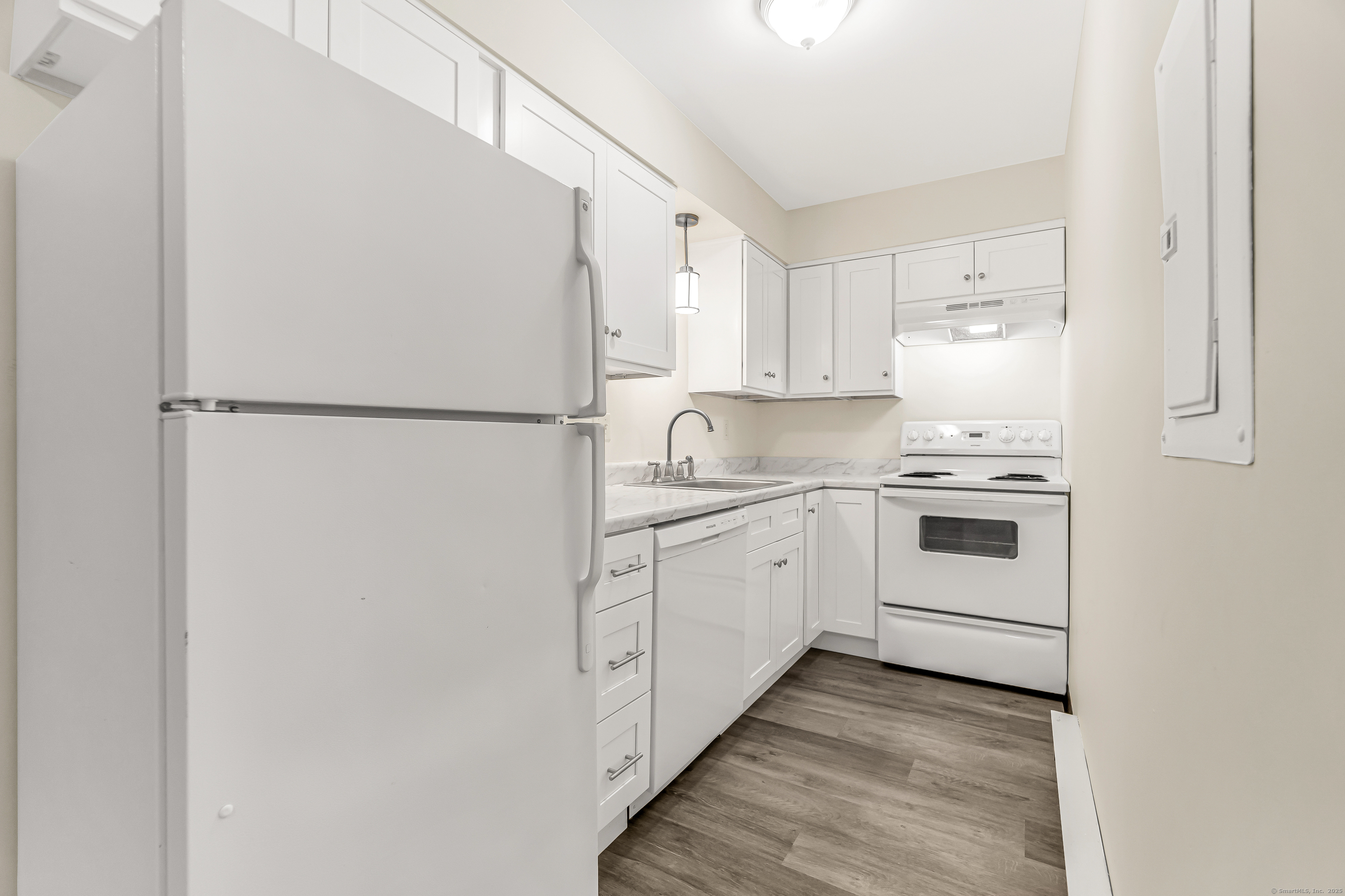 115 Short Beach Road, Unit 103 Stratford, CT 06615 - Photo 10 of 18 a kitchen with white cabinets and white appliances