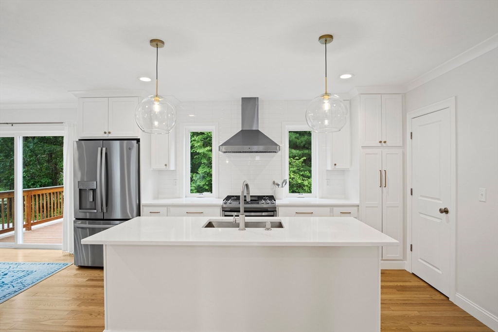 6 Sandy Pond Road Ayer, MA 01432 - Photo 5 of 37 a kitchen with stainless steel appliances a dining table chairs and wooden floor