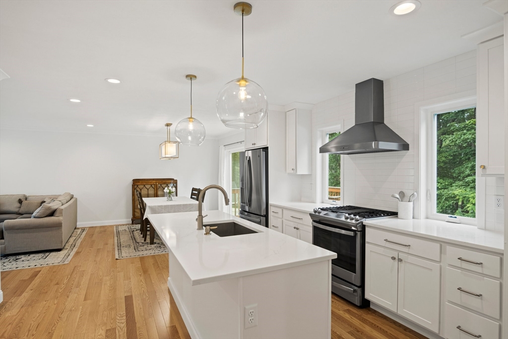 6 Sandy Pond Road Ayer, MA 01432 - Photo 8 of 37 a kitchen with stainless steel appliances a stove a chimney a sink and a wooden floor