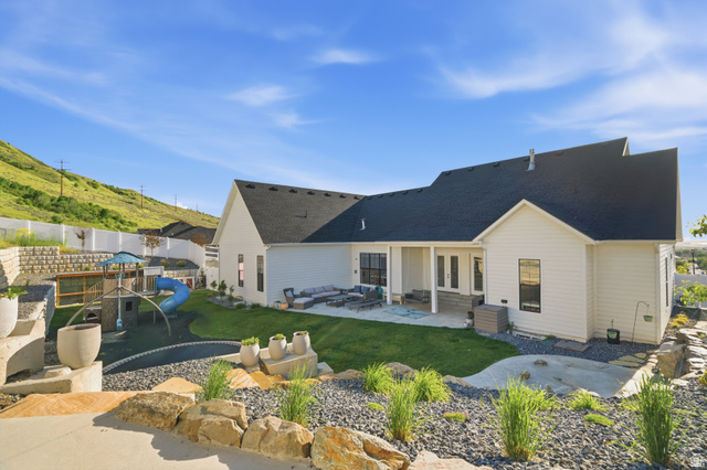 2013 South 100 West Perry, UT 84302 - Photo 37 of 49 Expansive backyard featuring a manicured lawn, a built-in trampoline, and a terraced retaining wall