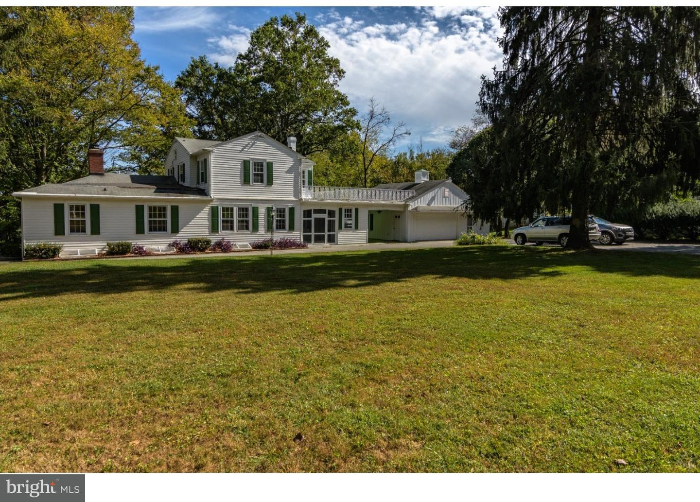 a view of a house with swimming pool and trees in the background