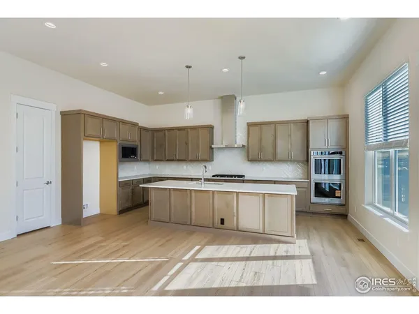 a open kitchen with stainless steel appliances granite countertop a stove a sink dishwasher and a refrigerator with wooden floor