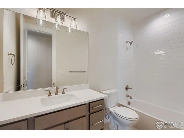 a bathroom with a sink double vanity granite tub shower and a mirror