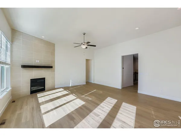 a view of an empty room with a fireplace and a window