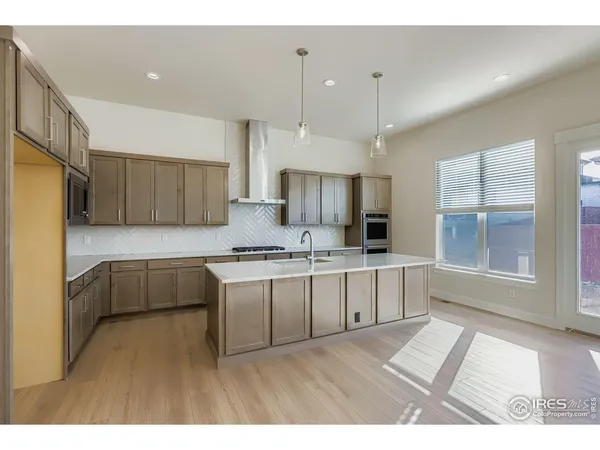a large kitchen with kitchen island a sink stainless steel appliances and cabinets