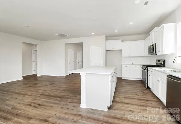 a kitchen with cabinets and wooden floor