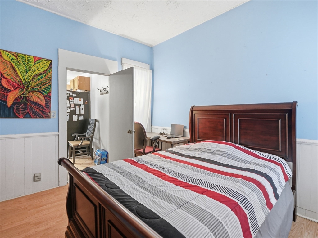 223 Stackpole Street Lowell, MA 01852 - Photo 11 of 42 a bedroom with a bed and wooden floor