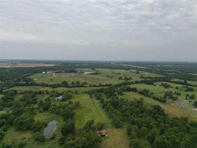 an aerial view of field with trees