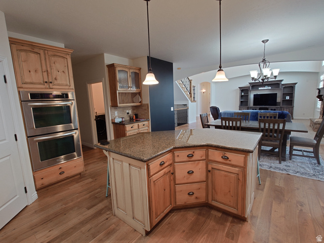 552 Sunset Crest Way Draper, UT 84020 - Photo 4 of 68 Kitchen featuring stainless steel double oven, a kitchen bar, hanging light fixtures, and backsplash