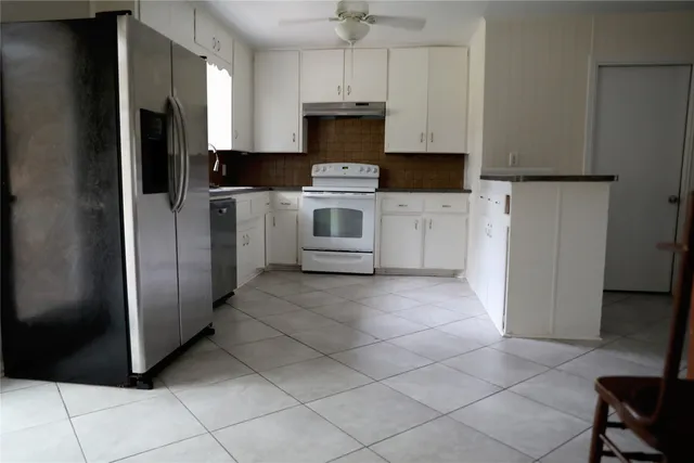 a kitchen with cabinets and stainless steel appliances