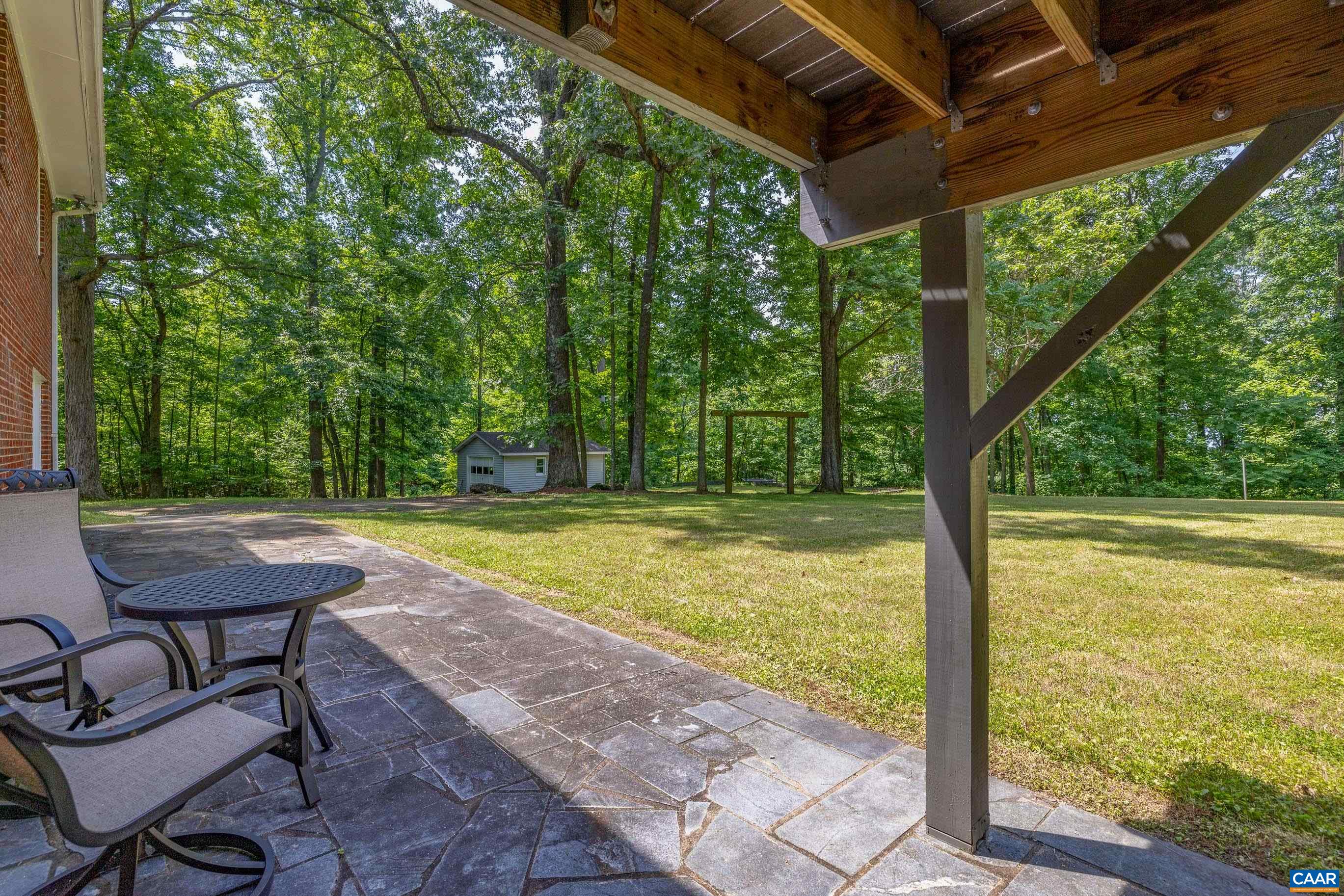 7250 Amicus Road Ruckersville, VA 22968 - Photo 7 of 74 a view of a chairs and table in the patio next to a yard