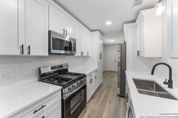 a kitchen with a sink stove and microwave