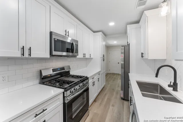 a kitchen with a sink stove and microwave