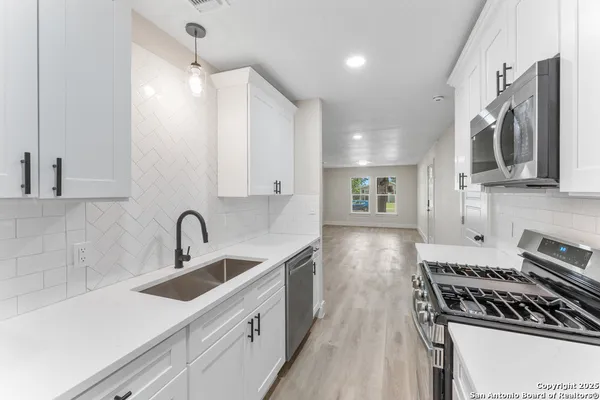 a kitchen with stainless steel appliances a sink stove and cabinets