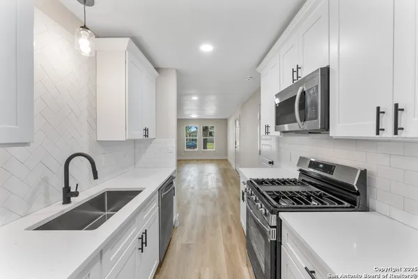 a kitchen with stainless steel appliances a sink stove and microwave