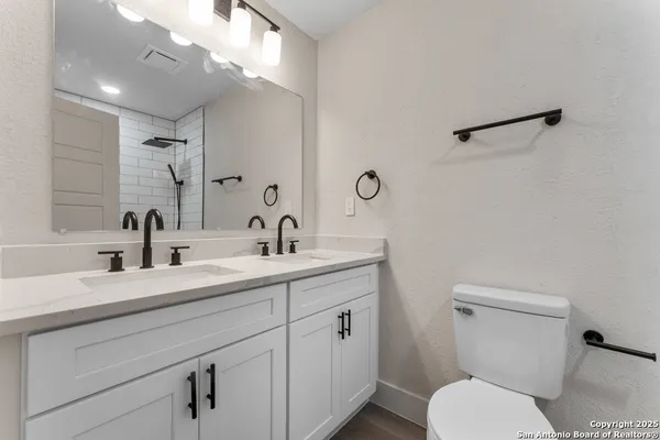 a bathroom with a toilet sink a mirror and vanity