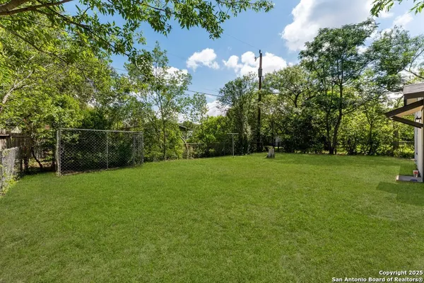 a view of a field of grass and trees