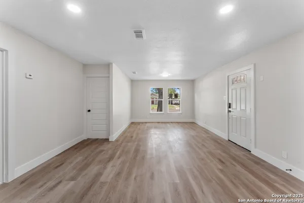 wooden floor in an empty room with a window