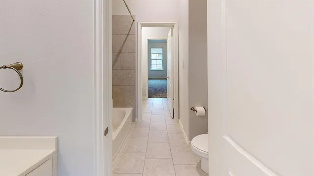 a bathroom with a granite countertop sink and a toilet