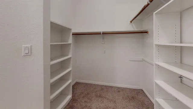 a view of walk in closet with empty racks