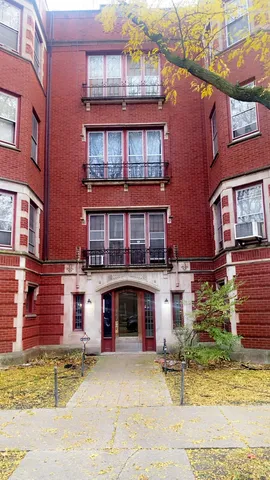 a front view of a brick building with a yard