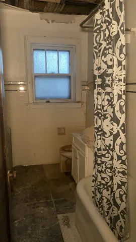 a bathroom with a toilet and a shower curtain