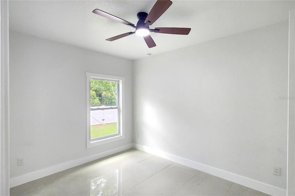 7027 Frascati Loop Wesley Chapel, FL 33544 - Photo 10 of 28 an empty room with windows and fan