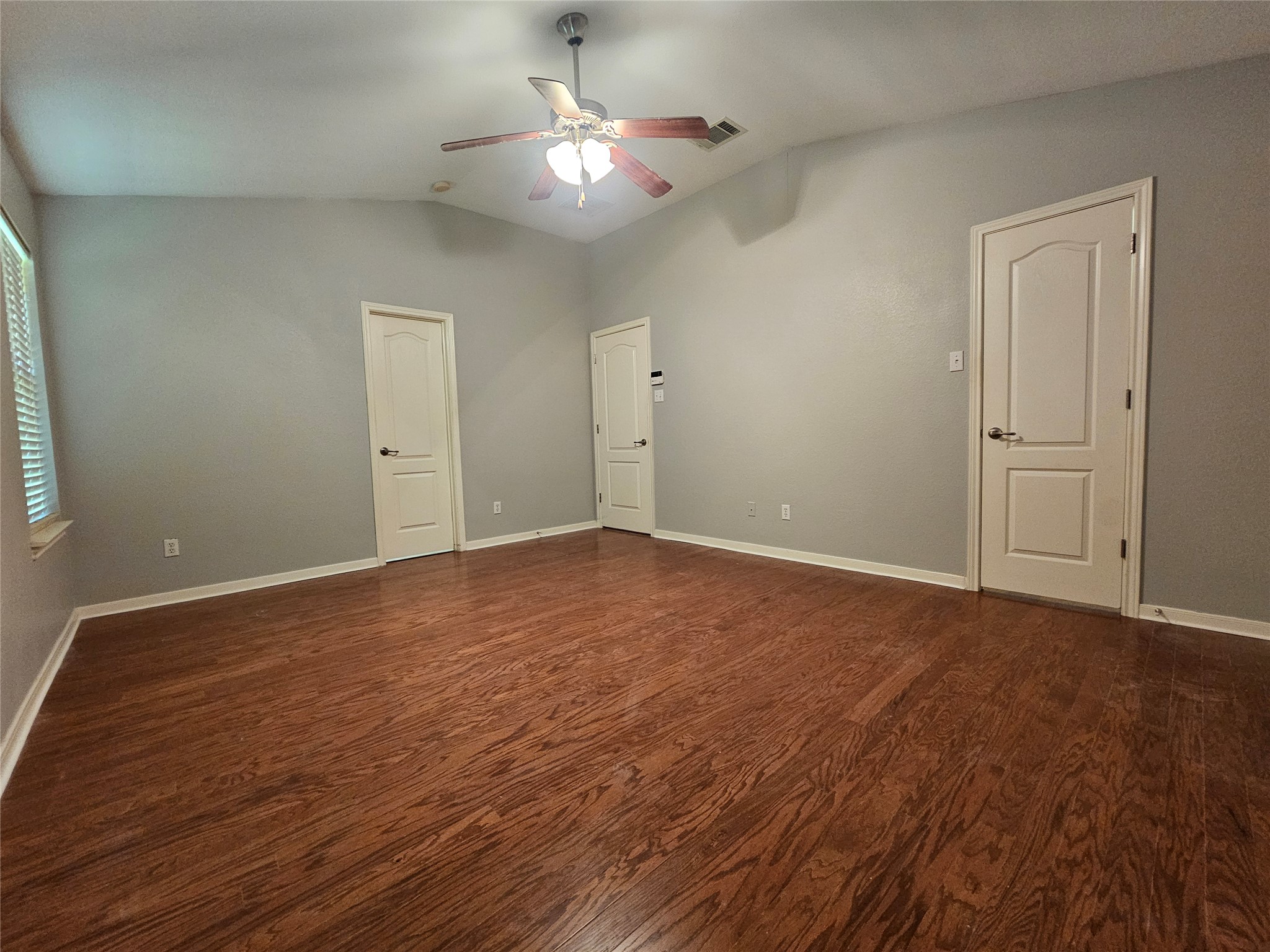 2035 Intrepid Drive Buda, TX 78610 - Photo 13 of 26 Rich hardwood floors complement the spacious interior, featuring high vaulted ceilings and a classic ceiling fan.