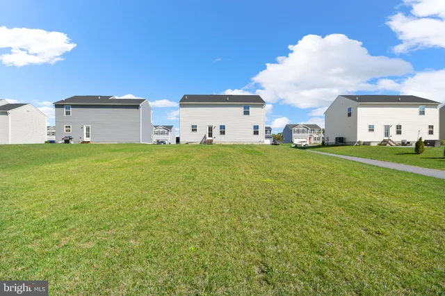 a view of a big house with a big yard and large trees