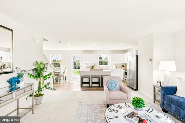 a kitchen with stainless steel appliances a dining table chairs and a refrigerator