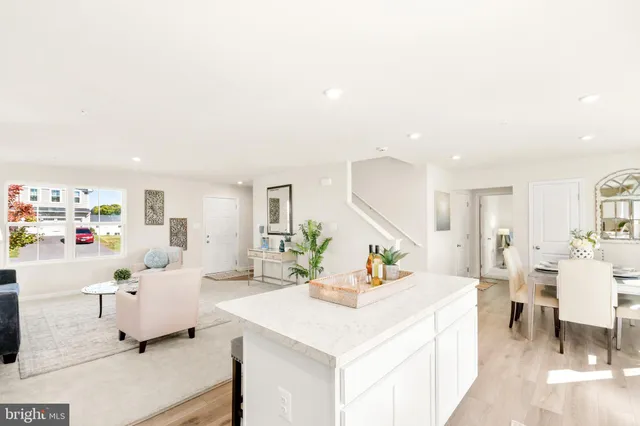 a large white kitchen with lots of counter top space a sink and cabinets