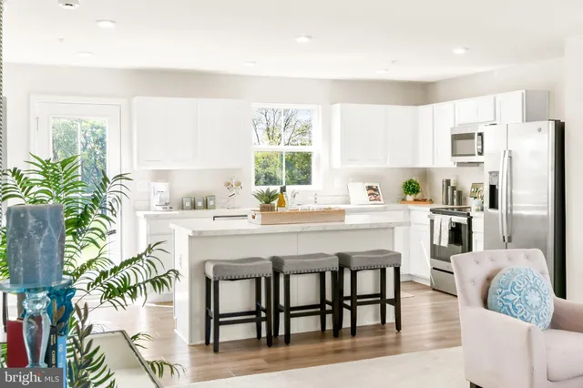 a kitchen with granite countertop white cabinets and stainless steel appliances