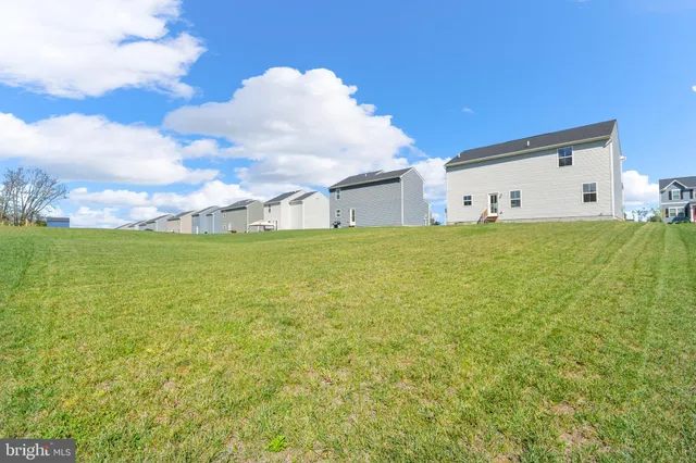 a view of a house with a big yard and large trees