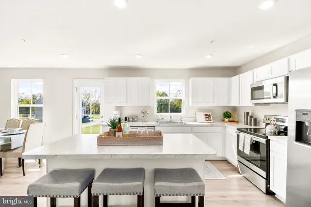 a kitchen with a dining table chairs and white appliances